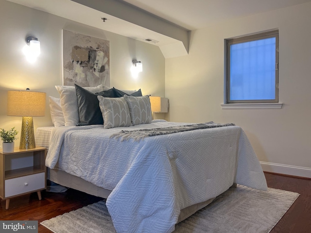 bedroom with wood finished floors and baseboards