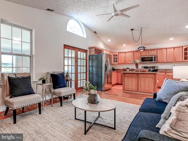 living area featuring a textured ceiling, light wood-style flooring, a ceiling fan, vaulted ceiling, and recessed lighting