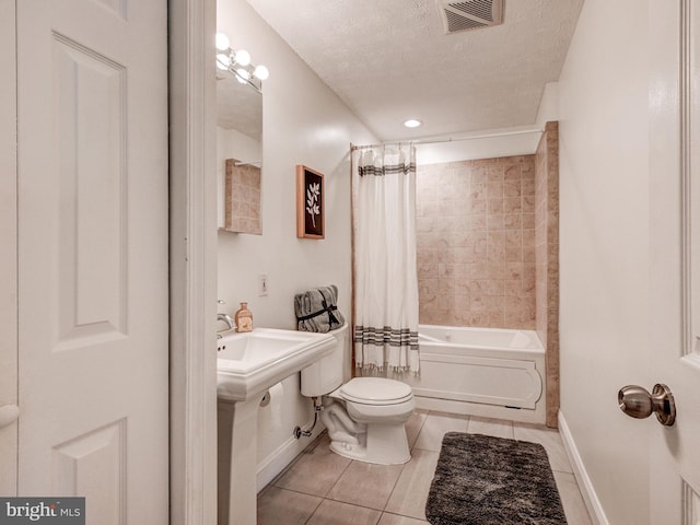 bathroom with tile patterned floors, baseboards, toilet, a textured ceiling, and shower / bath combination with curtain