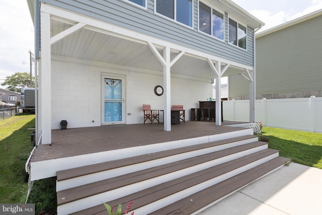 back of property with fence and a wooden deck