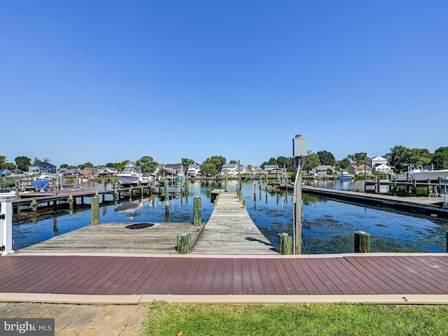 dock area featuring a water view, boat lift, and a residential view