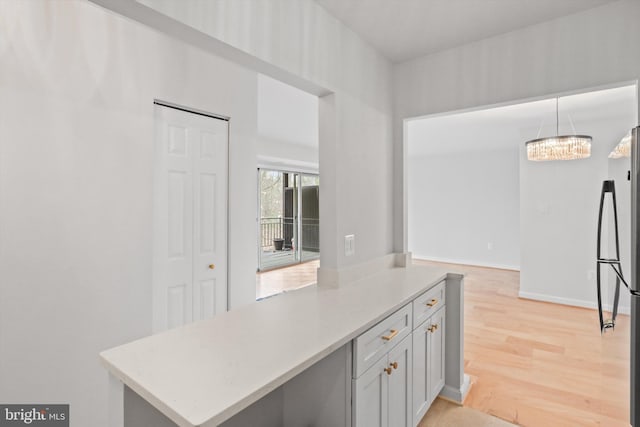 10167 Fair Woods Dr Unit 310, Fairfax, VA 22030 - kitchen featuring freestanding refrigerator, light wood-type flooring, light countertops, white cabinets, and pendant lighting
