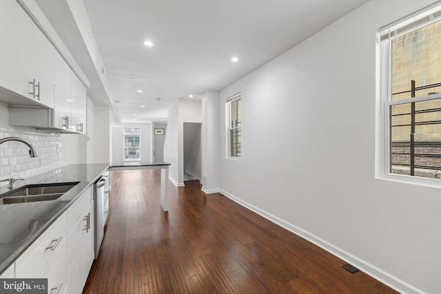 2514 Ashland Ave, Baltimore, MD 21205 - kitchen with a sink, baseboards, stainless steel dishwasher, white cabinets, and decorative backsplash