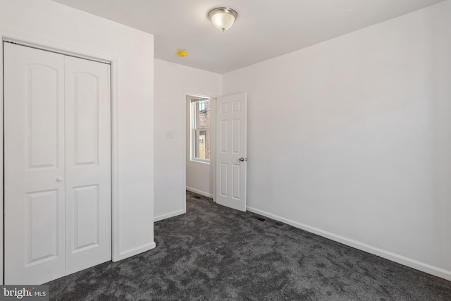 2514 Ashland Ave, Baltimore, MD 21205 - unfurnished bedroom featuring dark colored carpet, baseboards, and a closet