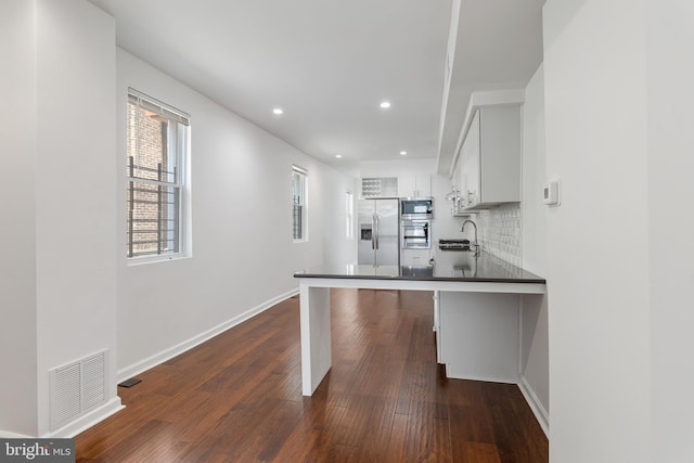 2514 Ashland Ave, Baltimore, MD 21205 - kitchen featuring appliances with stainless steel finishes, a sink, dark wood-style floors, baseboards, and decorative backsplash