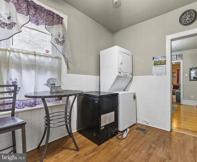 2022 Rowan St, Philadelphia, PA 19140 - laundry room featuring stacked washer / dryer, wood finished floors, and a wainscoted wall