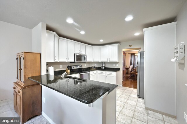 200 Sonny St, Hanover, PA 17331 - kitchen with appliances with stainless steel finishes, a peninsula, dark stone countertops, white cabinetry, and a sink