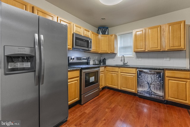 2458 N Natrona St, Philadelphia, PA 19132 - kitchen featuring appliances with stainless steel finishes, a sink, decorative backsplash, and dark wood-style flooring