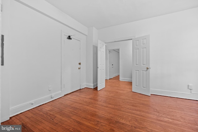 unfurnished bedroom featuring wood finished floors and baseboards