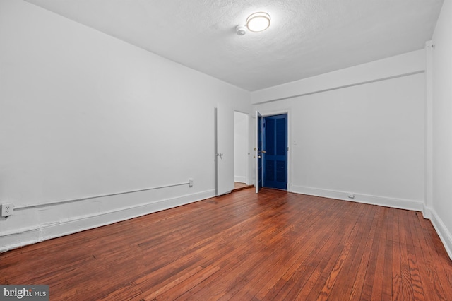 unfurnished room with hardwood / wood-style floors and baseboards