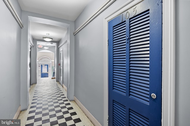 hallway featuring baseboards and tile patterned floors