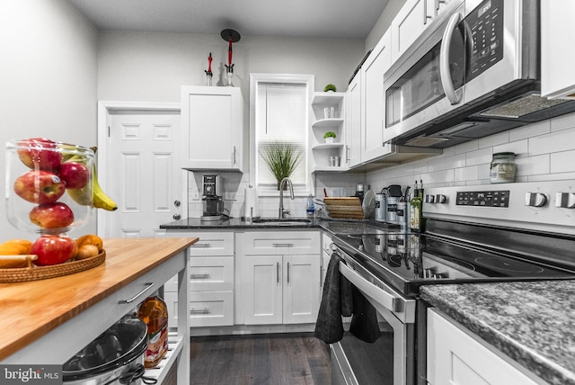 2460 N Natrona St, Philadelphia, PA 19132 - kitchen with stainless steel appliances, a sink, tasteful backsplash, white cabinets, and dark wood finished floors