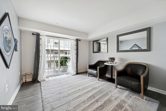 living area featuring baseboards and wood finished floors