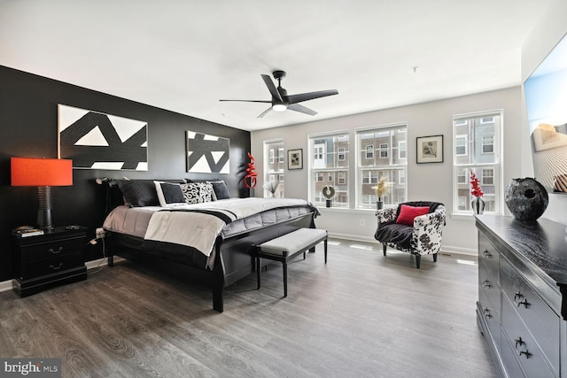 bedroom featuring dark wood finished floors, baseboards, and a ceiling fan