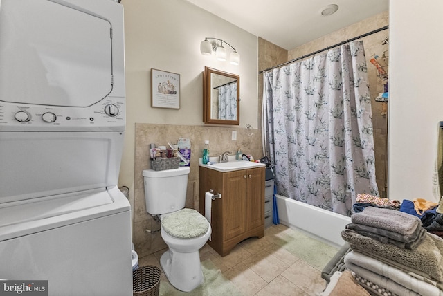 2466 N Natrona St, Philadelphia, PA 19132 - bathroom featuring estacked washer and dryer, tile walls, toilet, vanity, and tile patterned flooring