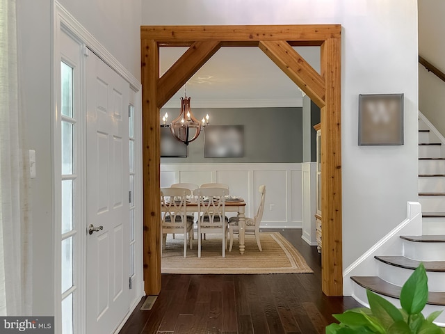 11372 Wollaston, Swan Point, MD 20645 - dining area with stairs, dark wood-type flooring, a decorative wall, a chandelier, and a wainscoted wall