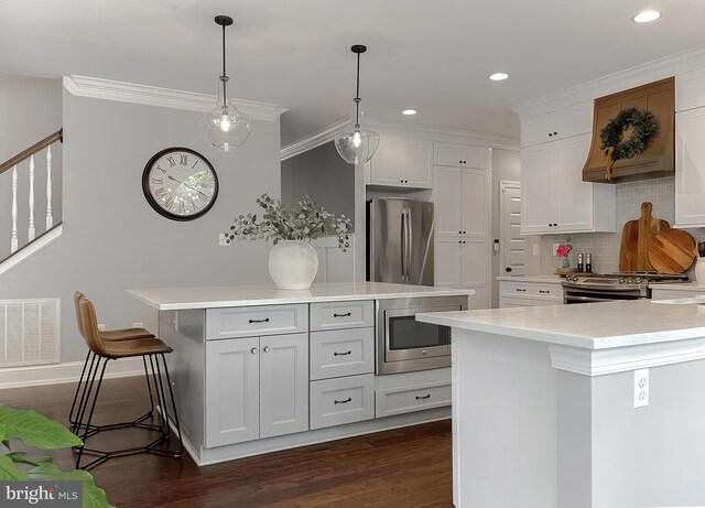 11372 Wollaston, Swan Point, MD 20645 - kitchen with appliances with stainless steel finishes, a kitchen island, dark wood-style flooring, light countertops, and backsplash