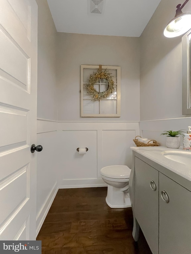 11372 Wollaston, Swan Point, MD 20645 - half bath featuring wood finished floors, toilet, vanity, and wainscoting