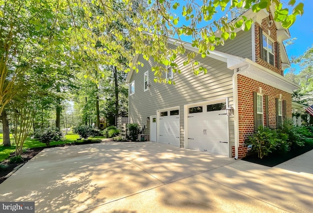 11372 Wollaston, Swan Point, MD 20645 - view of home's exterior featuring brick siding, a garage, and concrete driveway