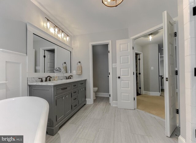 11372 Wollaston, Swan Point, MD 20645 - bathroom with toilet, double vanity, a soaking tub, and baseboards