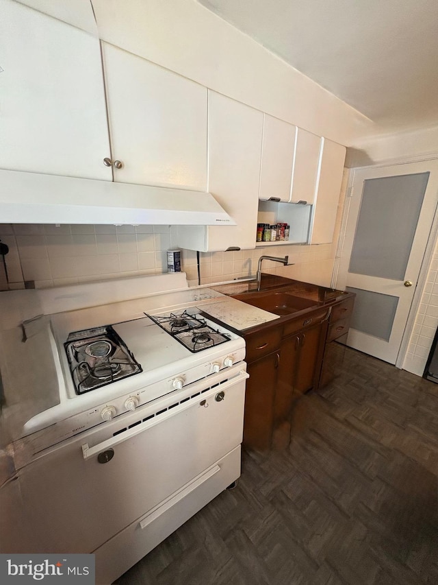 3630 Keystone Ave, Baltimore, MD 21211 - kitchen with white range with gas stovetop, under cabinet range hood, white cabinets, tasteful backsplash, and a sink
