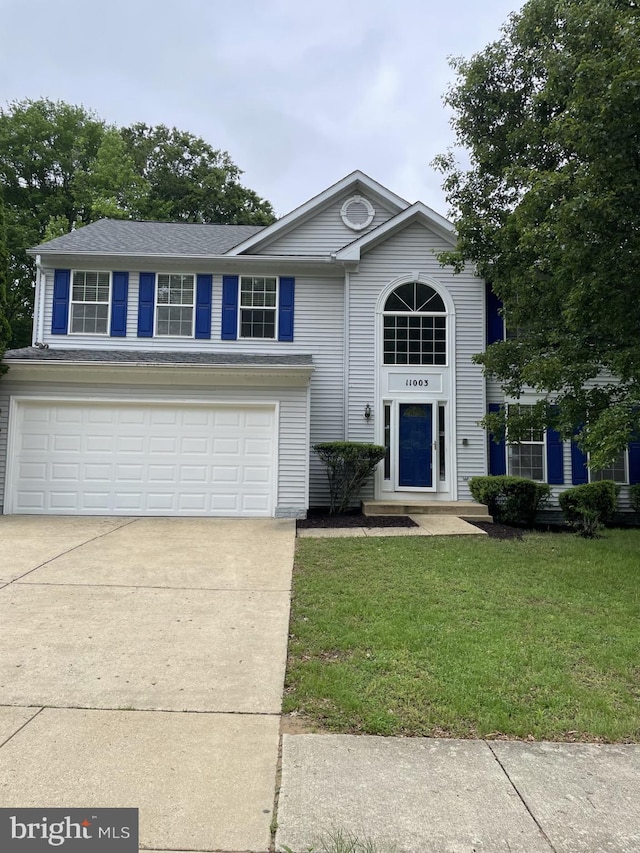 traditional-style home featuring an attached garage, concrete driveway, and a front lawn