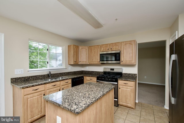 kitchen with stainless steel appliances, a sink, light brown cabinets, dark stone counters, and light tile patterned flooring