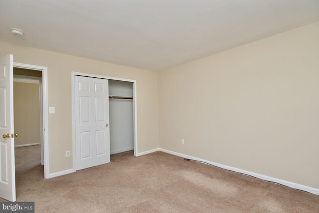 unfurnished bedroom featuring carpet floors, baseboards, and a closet