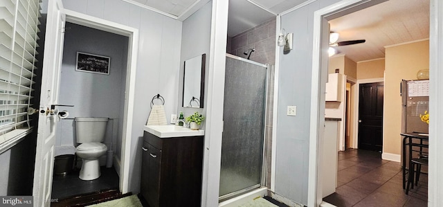 full bath with crown molding, a stall shower, toilet, vanity, and tile patterned flooring