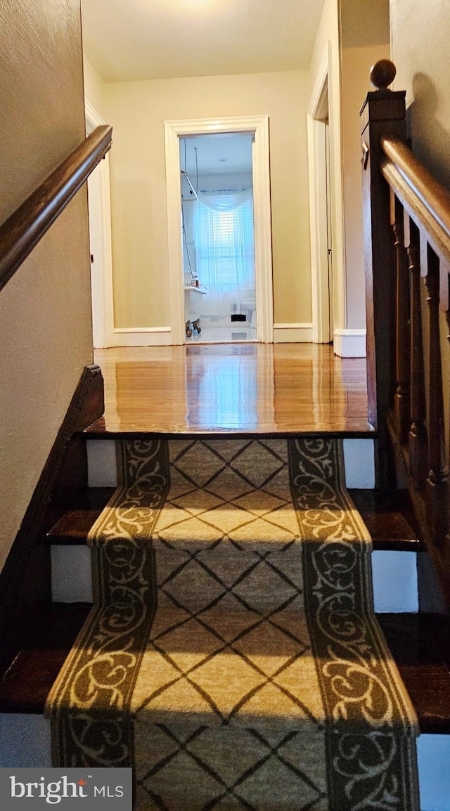 stairs with baseboards and wood finished floors