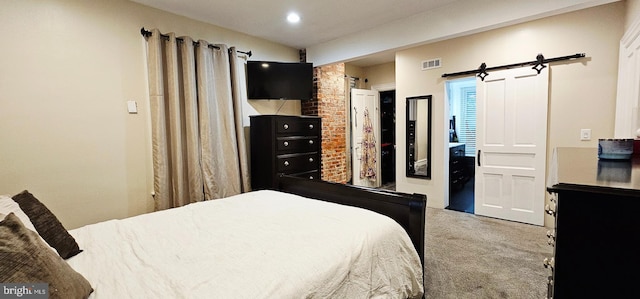 carpeted bedroom with a barn door