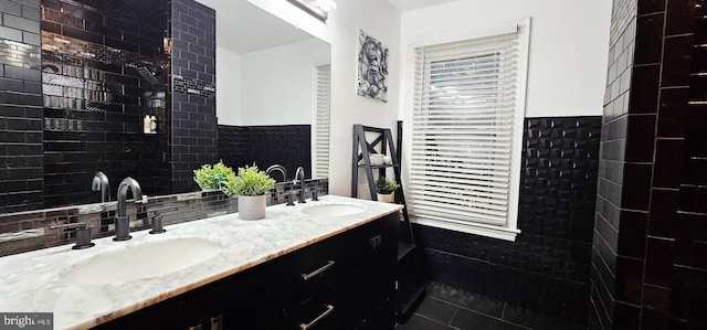 full bathroom featuring a wainscoted wall, tile walls, tile patterned floors, and double vanity