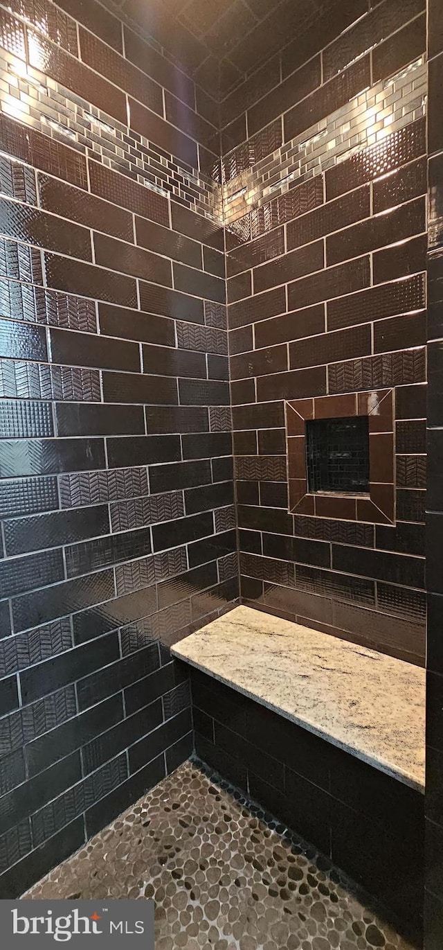 bathroom featuring a tile shower and a fireplace