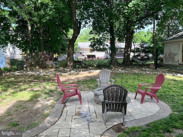 view of yard with a fire pit, a patio area, and fence