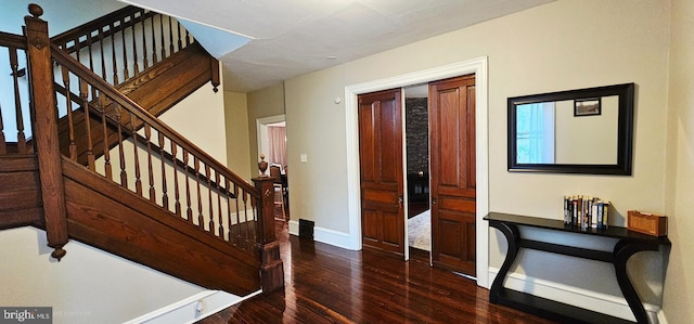 stairway featuring wood finished floors and baseboards