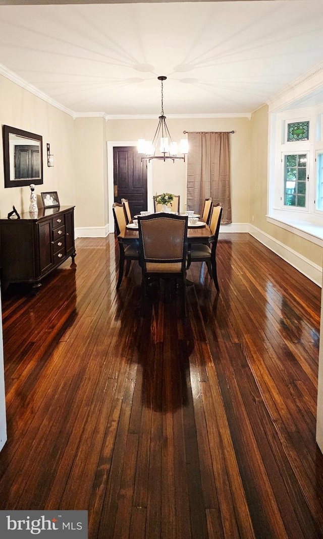 dining space featuring dark wood-style floors, a chandelier, baseboards, and crown molding