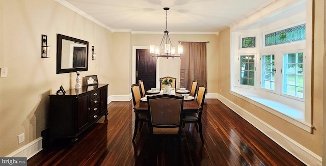 dining room featuring dark wood finished floors, a chandelier, crown molding, and baseboards