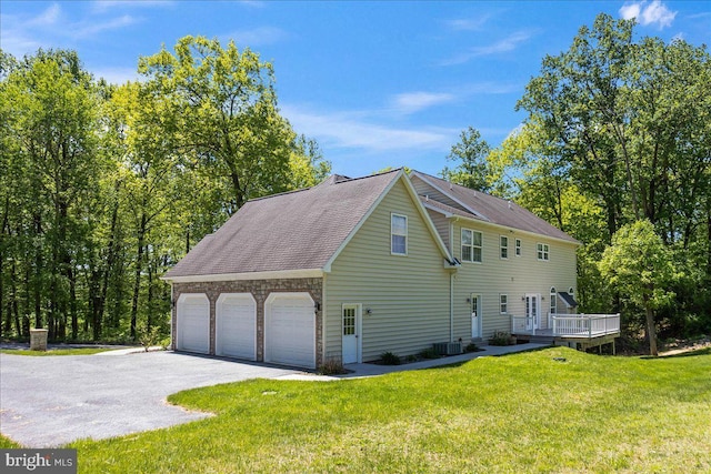 304 Iron Valley Dr, Lebanon, PA 17042 - view of side of home with a lawn, a deck, asphalt driveway, stone siding, and roof with shingles