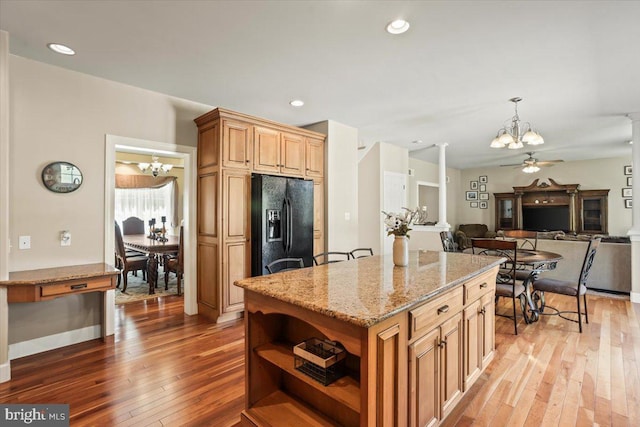 304 Iron Valley Dr, Lebanon, PA 17042 - kitchen with a chandelier, black fridge with ice dispenser, hardwood / wood-style flooring, open shelves, and light stone counters
