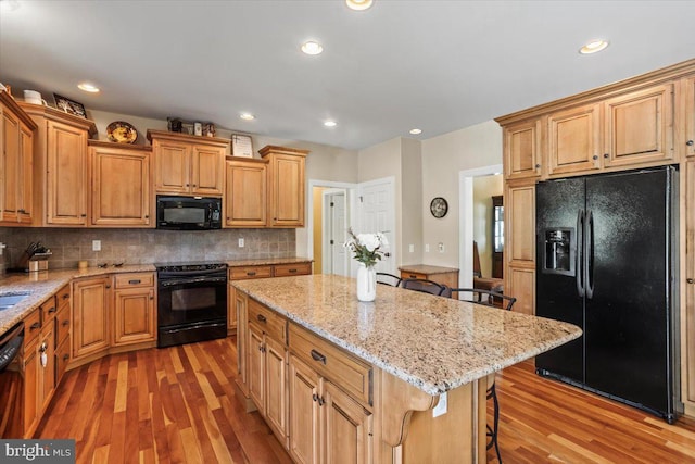 304 Iron Valley Dr, Lebanon, PA 17042 - kitchen featuring black appliances, light wood-style floors, a breakfast bar area, a center island, and recessed lighting