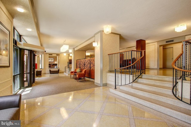 interior space with inlaid floor details, stairway, and a textured ceiling