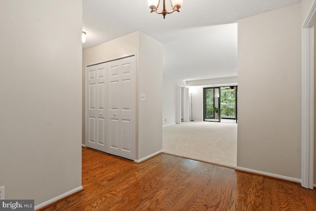 entrance foyer featuring wood finished floors, baseboards, and a chandelier