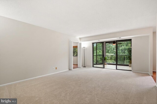 empty room featuring light colored carpet and baseboards
