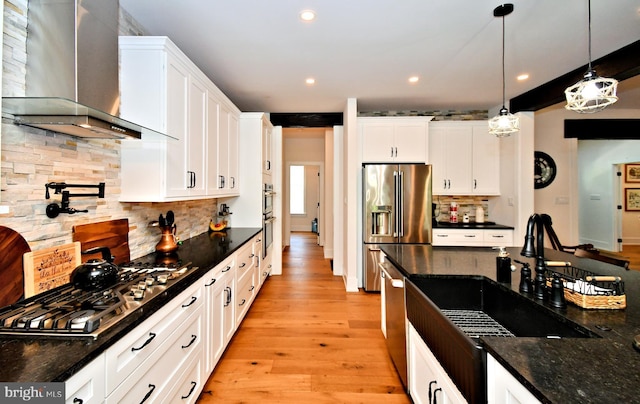 130 Schultz Rd, Sellersville, PA 18960 - kitchen with wall chimney range hood, stainless steel appliances, light wood-style floors, white cabinets, and decorative light fixtures