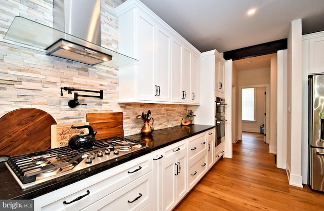 130 Schultz Rd, Sellersville, PA 18960 - kitchen featuring wall chimney exhaust hood, appliances with stainless steel finishes, decorative backsplash, white cabinets, and dark countertops