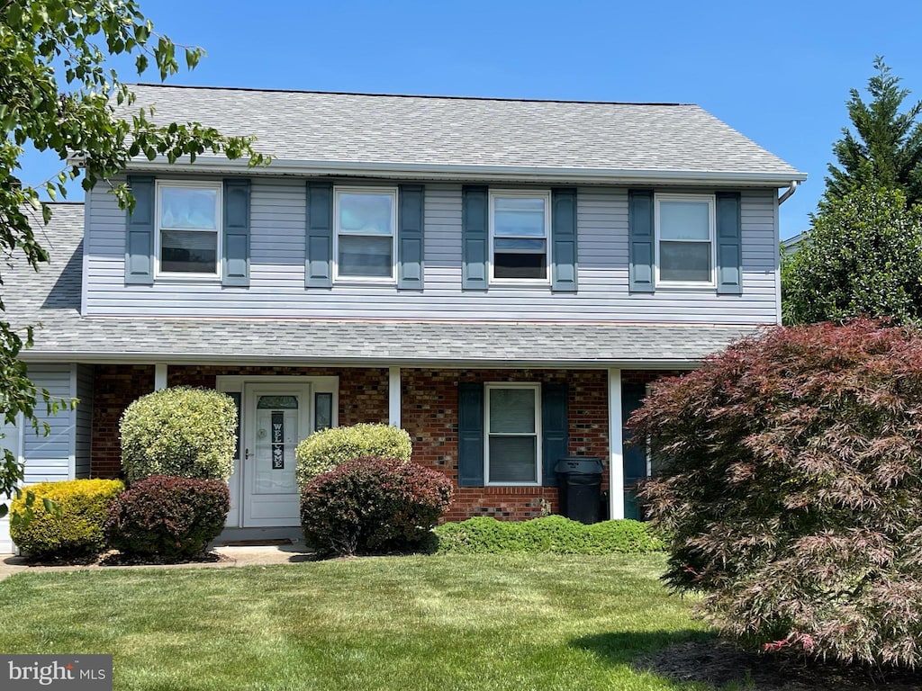 view of front of home with a front lawn and brick siding