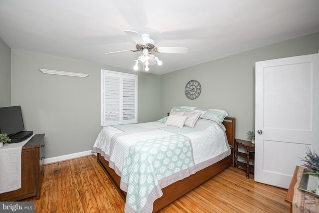 bedroom featuring wood finished floors, baseboards, and ceiling fan
