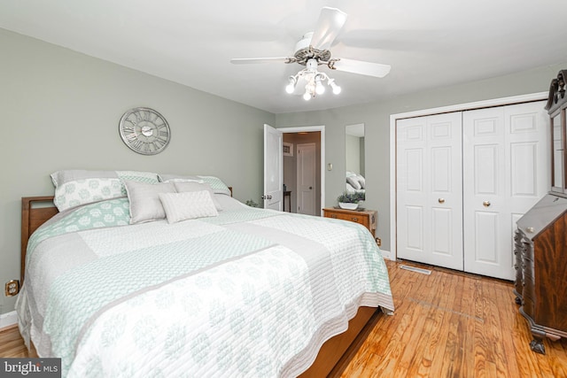 bedroom featuring a closet, light wood-type flooring, ceiling fan, and baseboards