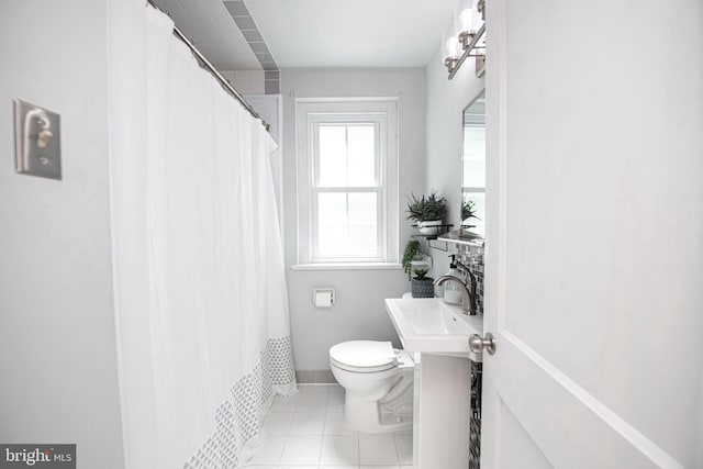 full bath with a sink, toilet, tile patterned flooring, and curtained shower