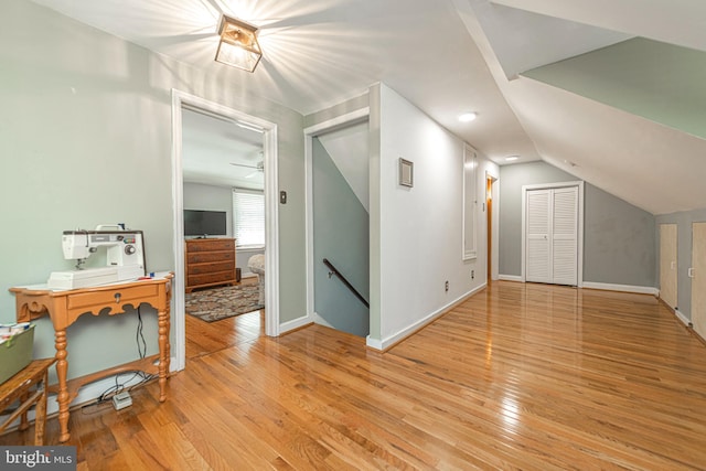 additional living space featuring lofted ceiling, wood-type flooring, and baseboards